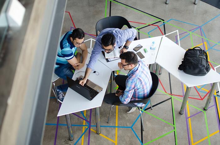 Colleagues working together around a laptop