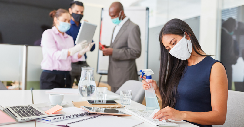 A woman is cleaning a desk at a hybrid event